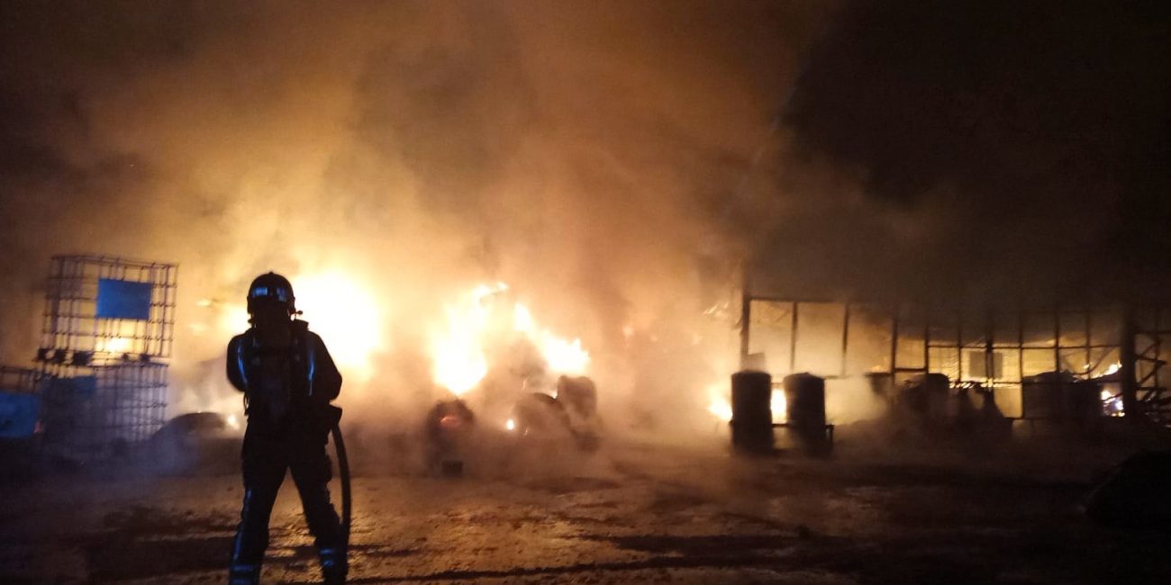 Firefighters control fire at a wood processing and waste management factory